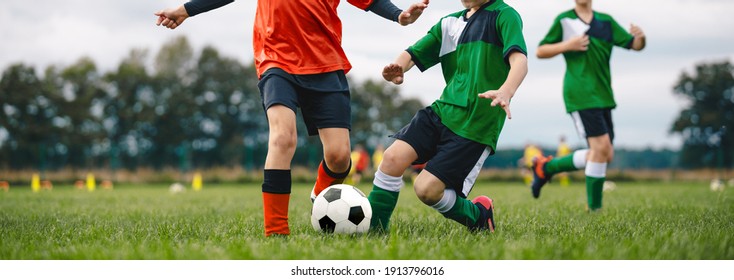 Players Kicking Football Ball On Grass. Young Boys In A Soccer Duel. Group Of School Children Playing Outoddr Sports On Soccer Pitch. Kids Compete In Football Match