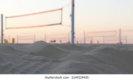 Players playing volleyball on beach court, volley ball game with ball and net, sunset palm trees silhouette, California coast, USA. Defocused people on sandy ocean shore. Seamless looped cinemagraph. - Shutterstock ID 2149229435