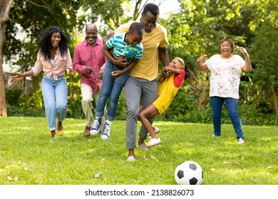 Playful african american multi-generational family playing soccer together in backyard on weekend. unaltered, family, togetherness, weekend and leisure concept. - Powered by Shutterstock