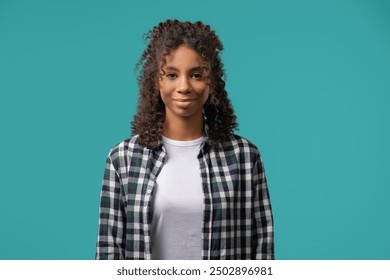 Playful african american stylish teenager girl smiling to camera on blue studio background. Cute lady in green shirt, casual outfit. High quality - Powered by Shutterstock