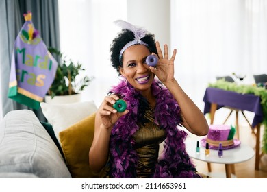 Playful African American Woman Having Fun With Food During Mardi Gras Party At Home. 