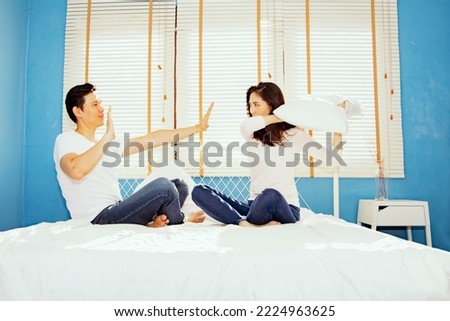 Playful asian couples use pillow fights on their mattresses because they resent something that men do not indulge and do as their girlfriend orders to make stupid women fight but men give up.
