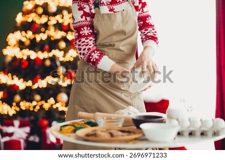 Playful baker in a cozy kitchen creates festive treats beside a glowing christmas tree and warm home holiday vibes
