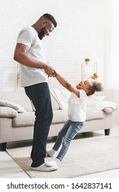 Playful Black Daughter Staying On Dad Feet, Learning Dancing At Home