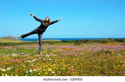 Playful Blonde Woman In The Field Full Of Flowers