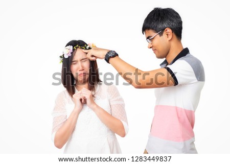 A playful boyfriend is blaming his girlfriend. While she is pretending to show her guilt. Studio scene on white background