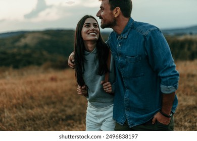 Playful couple enjoying a beautiful sunset in the hills, embracing and running in their love - Powered by Shutterstock