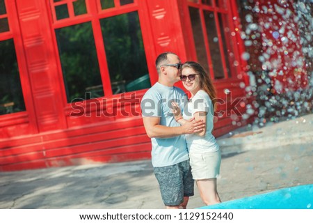 Playful couple lovers having fun together outdoor near fountain, play with water on bright urban background. Relationship Love Emotions Lifestyle People Fashion Urban streetsty Family