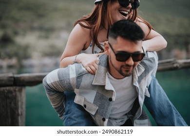 A playful couple shares joyful laughter during an outdoor trip, highlighting their vacation on a lakeside dock. - Powered by Shutterstock