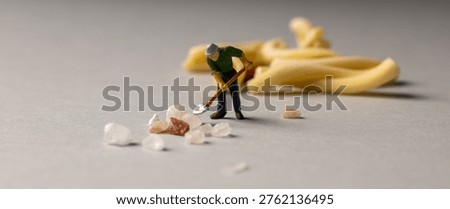 a playful and creative conceptual image featuring tiny miniature people figures working on uncooked pasta