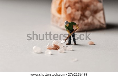 a playful and creative conceptual image featuring tiny miniature people figures working on uncooked pasta