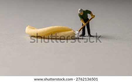 a playful and creative conceptual image featuring tiny miniature people figures working on uncooked pasta