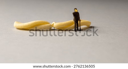 a playful and creative conceptual image featuring tiny miniature people figures working on uncooked pasta