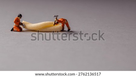 a playful and creative conceptual image featuring tiny miniature people figures working on uncooked pasta