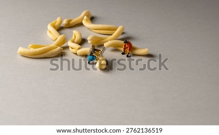 a playful and creative conceptual image featuring tiny miniature people figures working on uncooked pasta