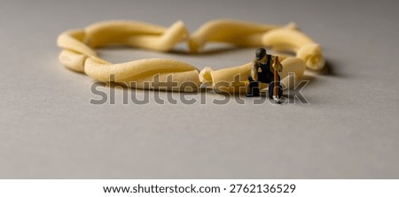 a playful and creative conceptual image featuring tiny miniature people figures working on uncooked pasta