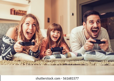 Playful family playing video games together in a living room. - Powered by Shutterstock