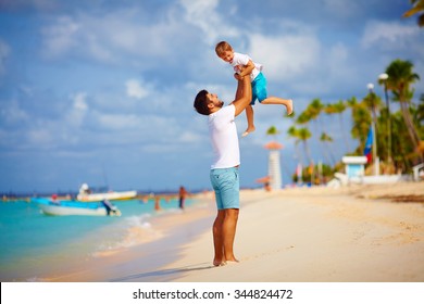 playful father and son having fun on tropical beach