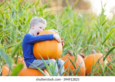 Playful Funny Boy Being Silly And Enjoying Pumpkin Patch