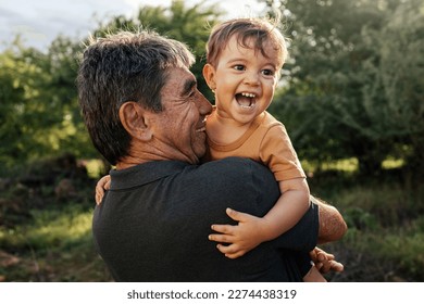 Playful grandfather spending time with his grandson in park on sunny day - Shutterstock ID 2274438319