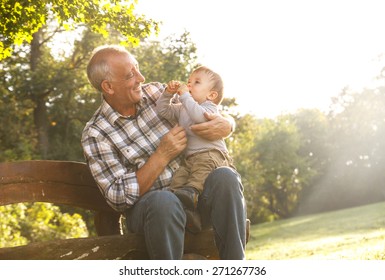 Playful grandfather spending time with his grandson in park