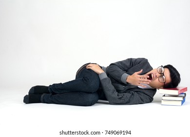 Playful happy young man funny round glasses lying with book over white background