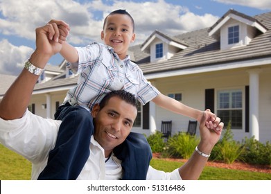 Playful Hispanic Father and Son in Front of Beautiful House.