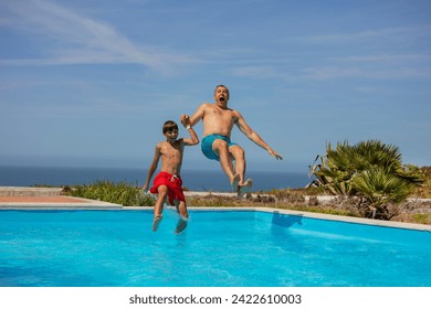 Playful jump into a water pool by a man and youngster with a vast ocean in the distance, fun on summer vacations - Powered by Shutterstock