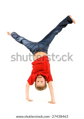 Playful lad standing on his arms with legs pointing upwards over white background