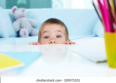 Playful Little Boy Hiding Under The Table