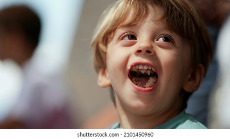 Playful little boy opening mouth with food inside. mischievous child misbehaving