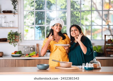 Playful little Indian asian girl cooking with her mother - Powered by Shutterstock