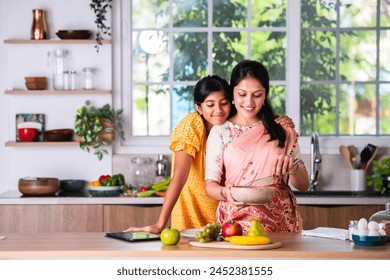 Playful little Indian asian girl cooking with her mother - Powered by Shutterstock