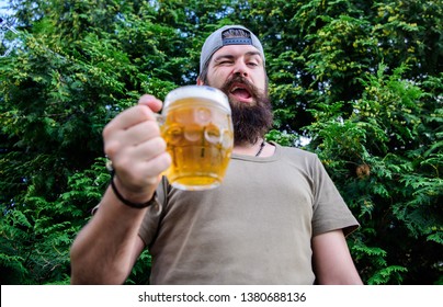 In Playful Mood. Brutal Hipster With Winking Face Having Craft Beer. Man Drinker Holding Beer Mug. Bearded Man Enjoy Drinking Beer On Nature. Fun Loving Beer.