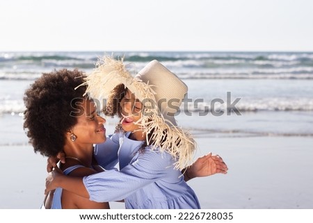 Playful mother and daughter spending time on beach. African American family walking, hugging, laughing, fooling around. Leisure, family time, togetherness concept