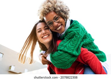 Playful Multiracial Female Lesbian Couple Looking At Camera. Black Woman Piggyback Ride With Girlfriend. Copy Space.