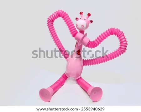 A playful pink giraffe toy with flexible arms and legs that can be stretched and posed in many different ways. Perfect for sensory play and imaginative fun