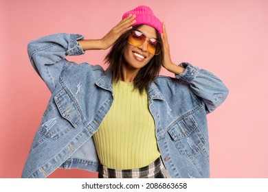 Playful smiling woman in stylish winter outfit posing pink background  Stylish suglases and gradient  Jeans jacket   Trendy  look  