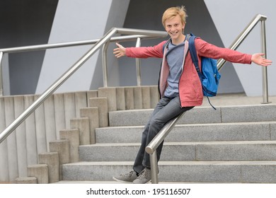 Playful Teenage Student Sliding Down Railing On School Stairway