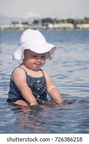 Playful toddler splashing around at the beach having fun