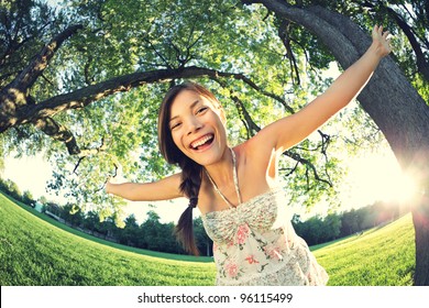 Playful woman in spring having fun in park smiling happy playing joyful. Beautiful young multicultural woman outside on sunny day.