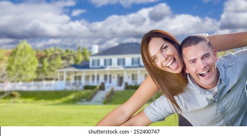 Playful Young Military Couple Outside A Beautiful New Home.