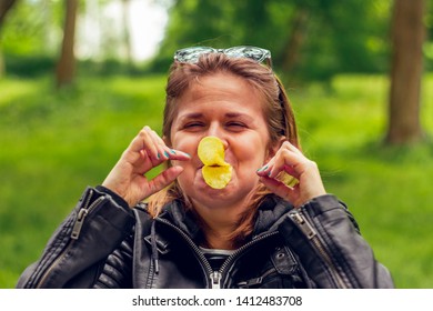 Playful Young Woman Wearing Leather Jacket, Making A Duck Beak From Potato Chips In The Park – Pretty Grill Feeling God And Joyful Playing With Snacks