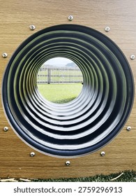 Playground Tunnel View with Circular Pattern and Outdoor Background