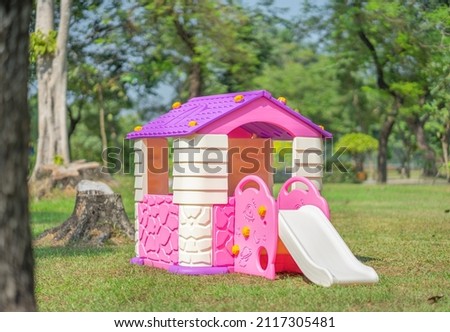 playhouse with slides in backyard spring garden.plastic colorful house Entertainment area.