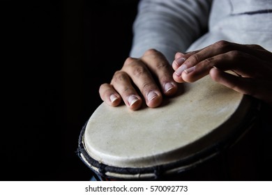 Playing African Drums In Low Key Single Light By Musician In Music Studio, West Africa.