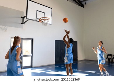 Playing basketball, female athletes practicing shooting on indoor school court. Sports, practice, teamwork, competition - Powered by Shutterstock