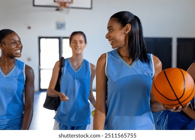 Playing basketball, female athletes smiling and interacting in school gymnasium. Sports, teamwork, exercise, active, competition, high school - Powered by Shutterstock