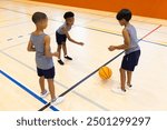 Playing basketball in school gym, three boys practicing dribbling and passing. Sports, teamwork, practice, gymnasium, exercise, fitness