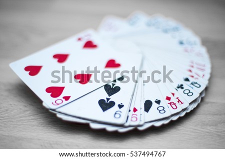 Playing cards deck isolated on a gray wooden background - red, black, and white colors